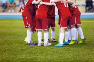 Children playing football to develop teamwork skills