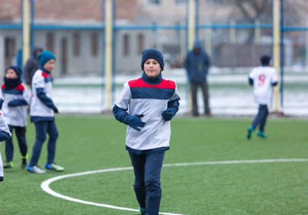 Children playing sports outdoors in winter Children playing sports outdoors in winter